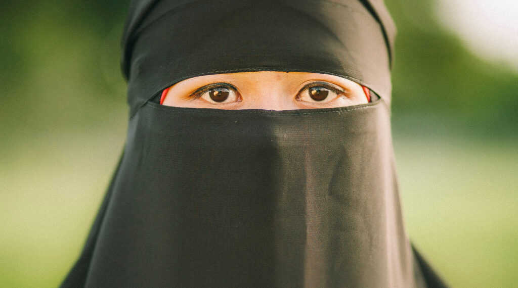 woman wearing a black niqab with only her eyes showing.