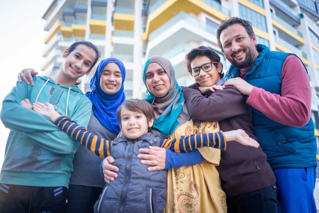 Muslim family on city street together taking a picture