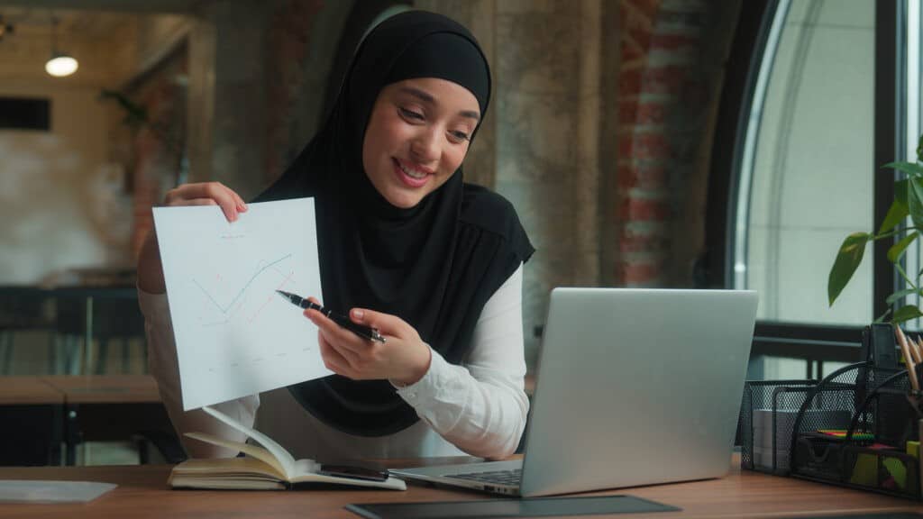 muslim girl in hijab in a meeting, smiling at computer 