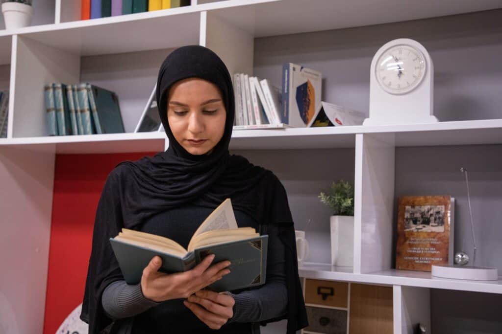 Muslim woman wearing a black hijab in a library